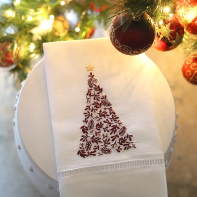 Toalha branca com bordado de árvore de Natal bordô e estrela dourada