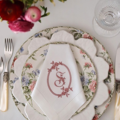 Conjunto de loiça floral com guardanapo bordado e talheres com cabo perolado