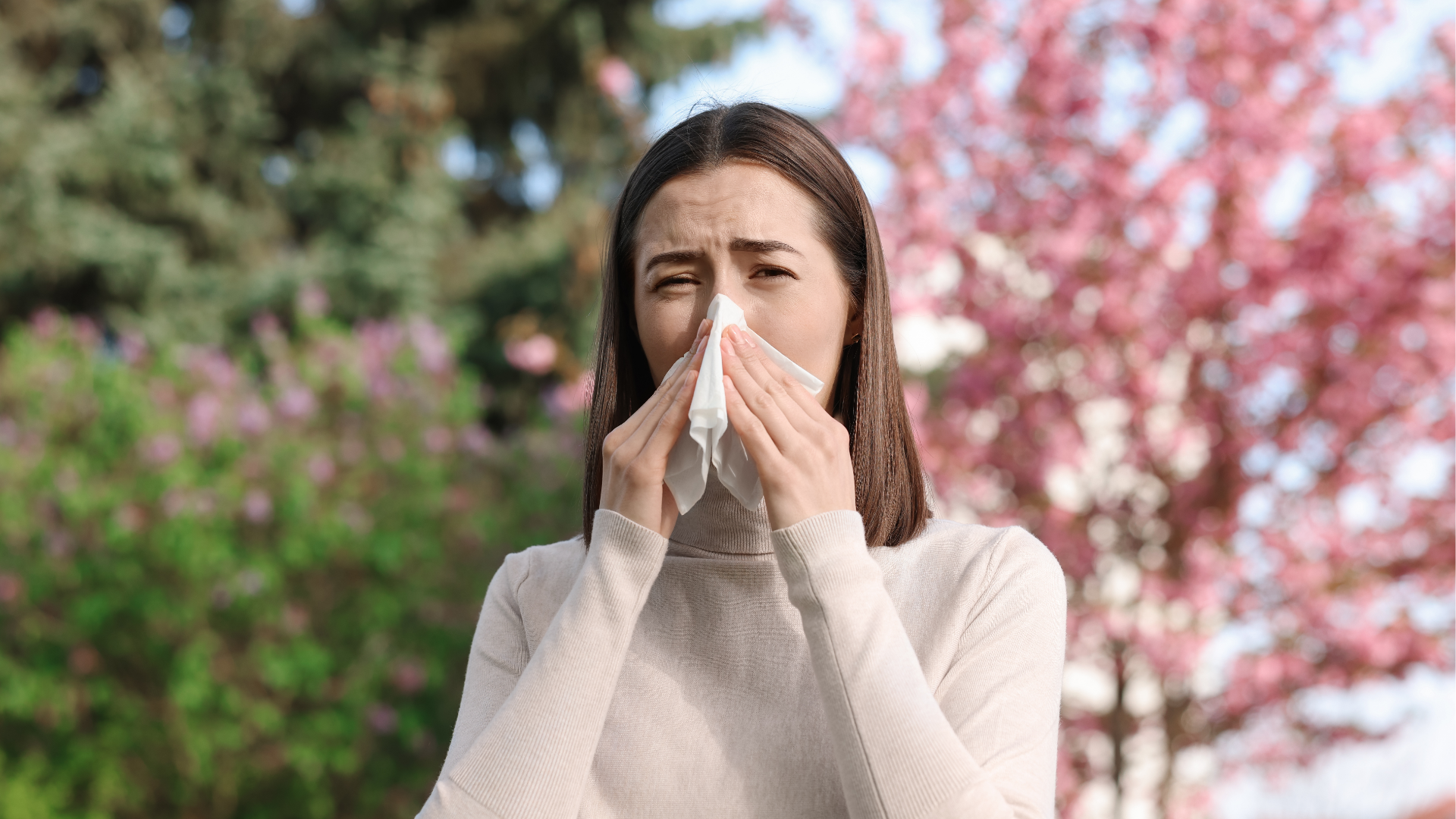 Mulher a assoar o nariz com lenço de papel branco ao ar livre