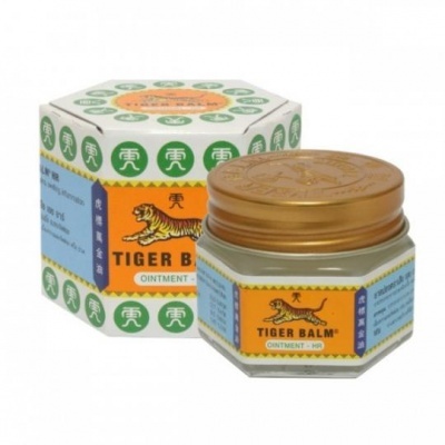 Frasco e embalagem da pomada Tiger Balm com tampa dourada e rótulo amarelo