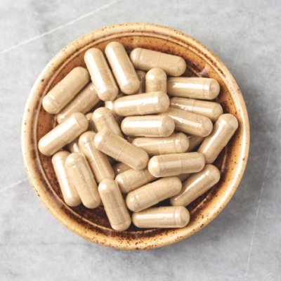 Prato com cápsulas beige sobre superfície cinza marmoreada