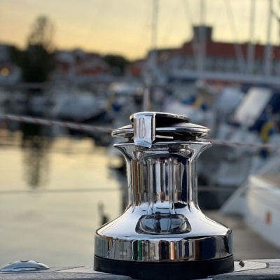 Guincho de barco cromado num porto ao entardecer