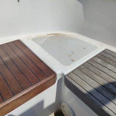 Superfícies de assento em madeira escura e clara com área central em plástico branco texturizado.