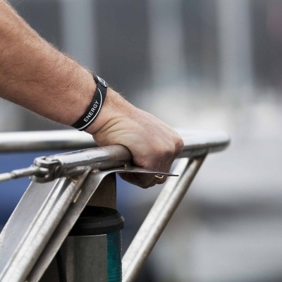 Pulseira preta de silicone com inscrição SILVERCREST no pulso segurando corrimão metálico