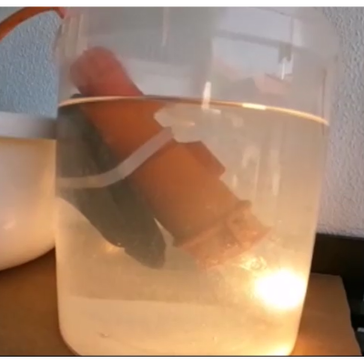 recipiente transparente com objetos flutuantes vermelhos e cinzentos em água