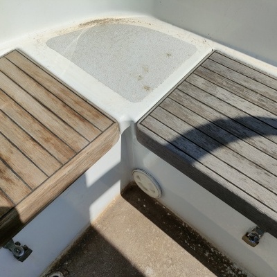 Bancos de madeira envelhecida sobre estrutura branca, com sombras projetadas.