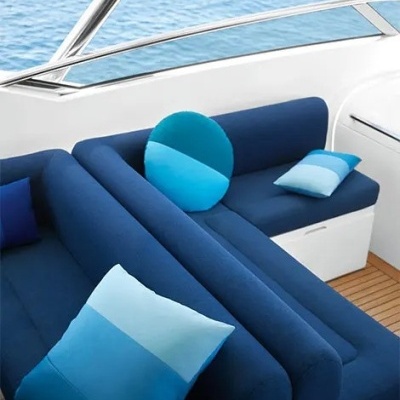 Sofás azuis com almofadas azuis num ambiente de barco com vista para o mar
