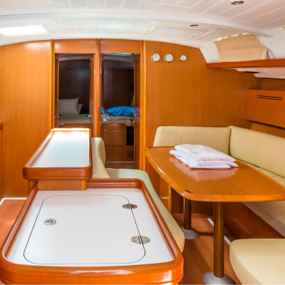 Interior de iate com mesa de madeira e bancos estofados em pele bege