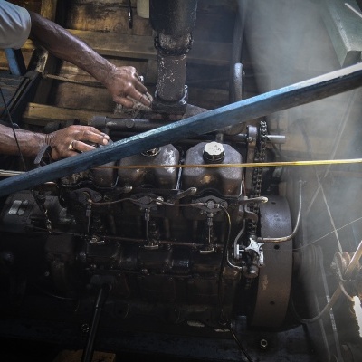 Motor antigo castanho operado por pessoa em ambiente industrial com azulejos brancos