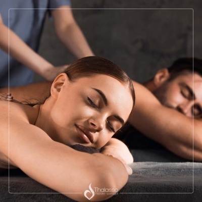 Casal a receber massagem num espaço de spa com logotipo Thalasso