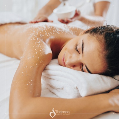 Pessoa a receber tratamento de massagem com sal grosso nas costas em spa