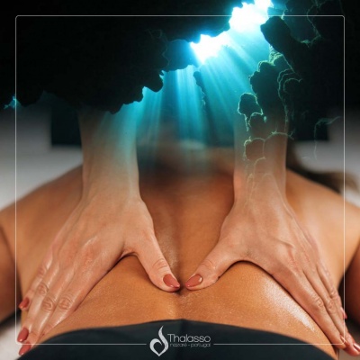 Pessoa a receber massagem nas costas com efeito visual de luz azul e caverna subaquática