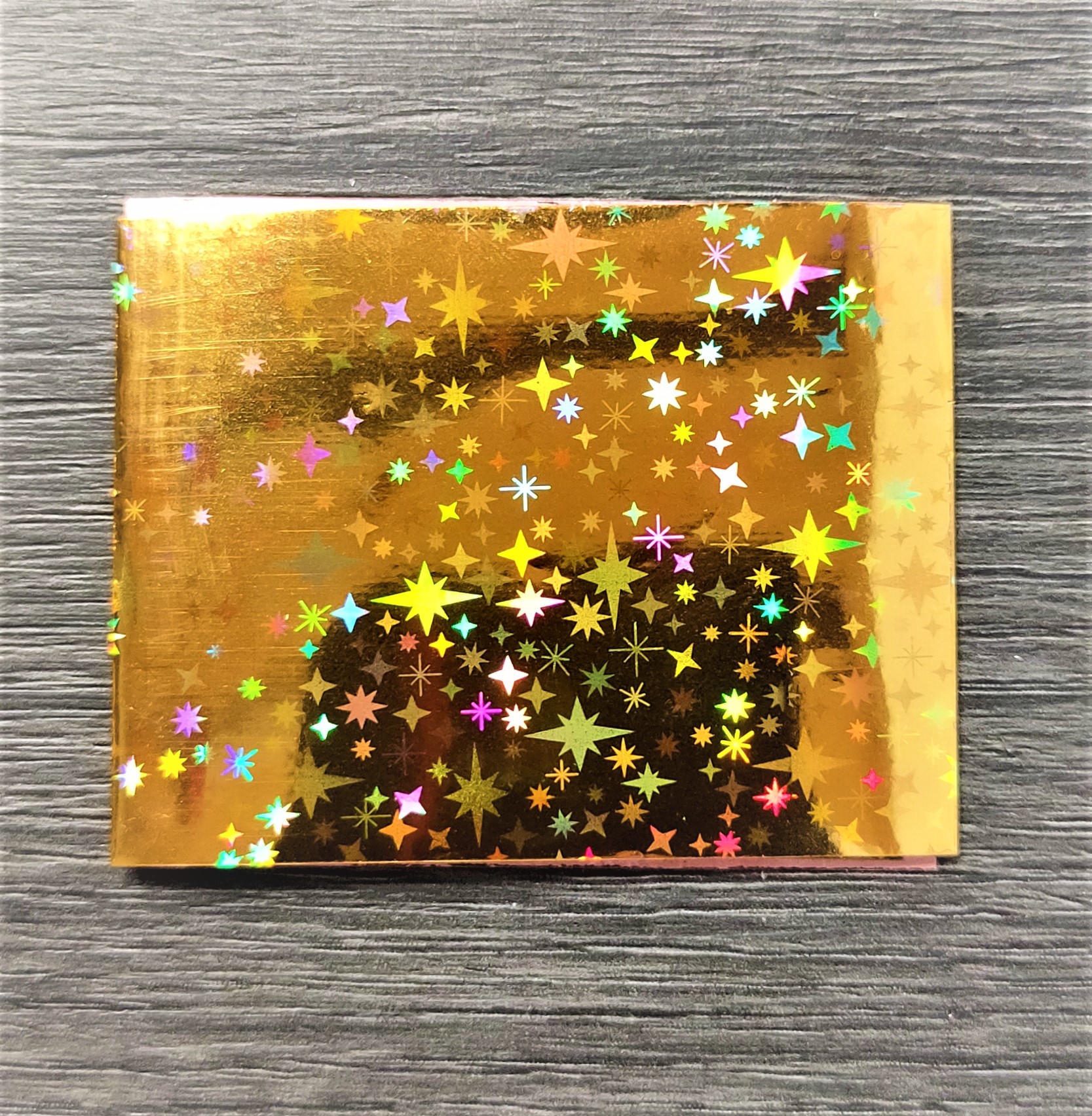 Caixa dourada brilhante com estrelas holográficas