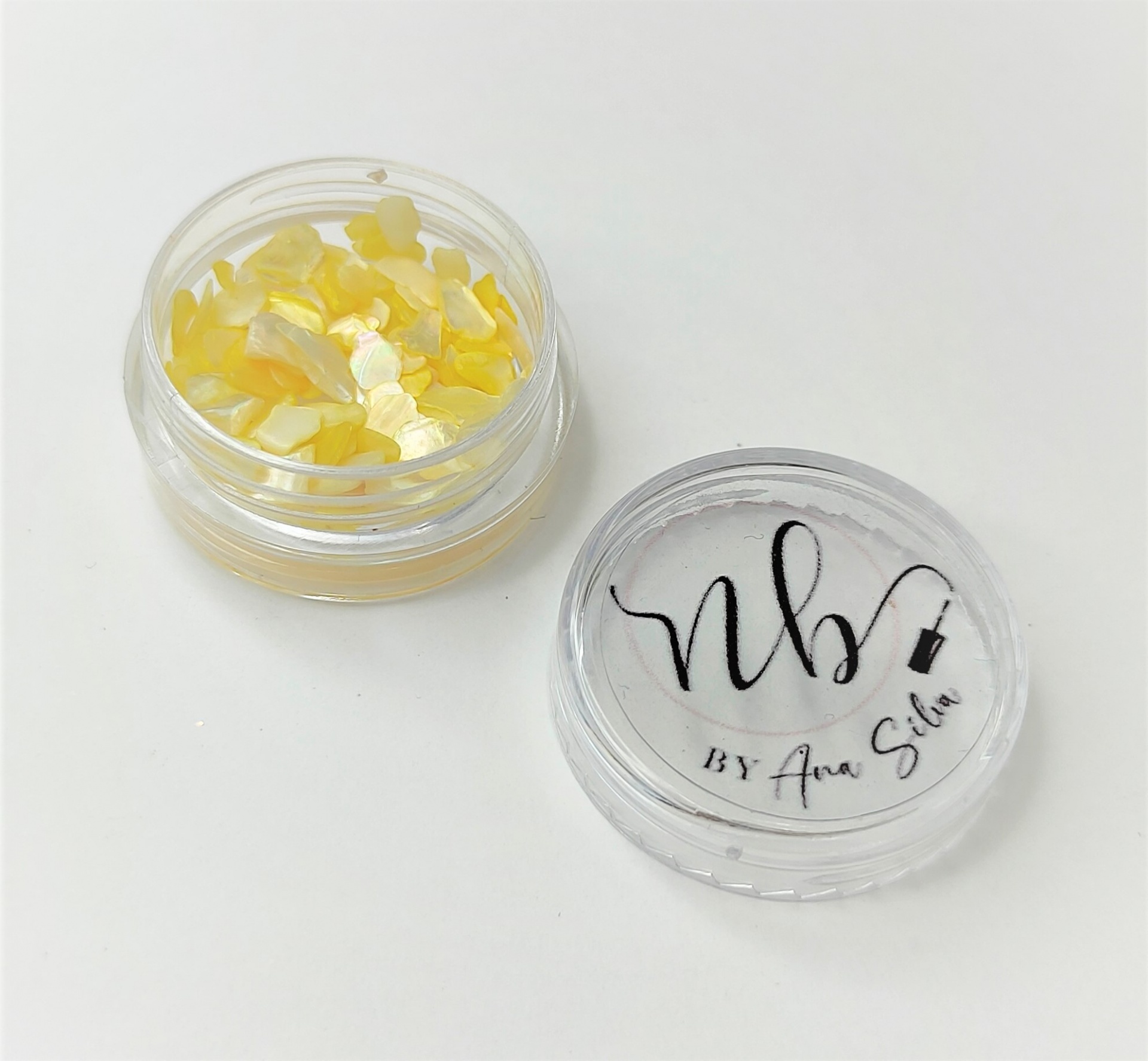 Frasco transparente com pequenos pedaços amarelos e tampa com texto nb by Ana Silva