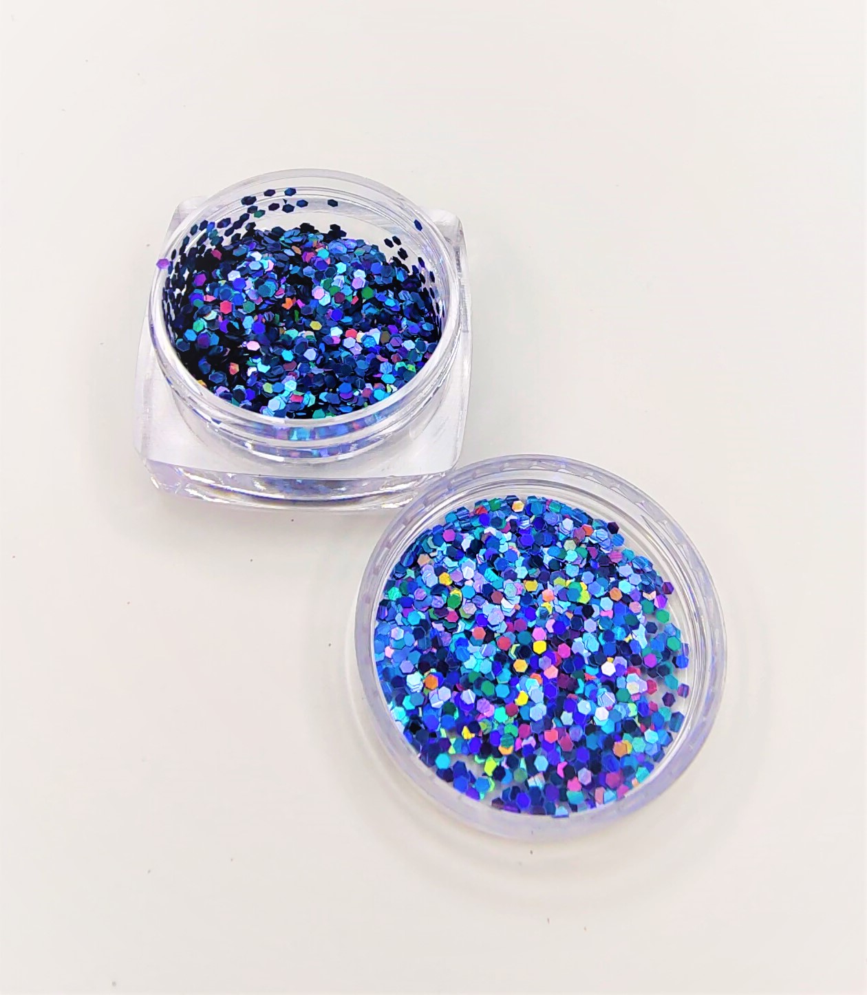 Dois frascos transparentes com glitter azul holográfico
