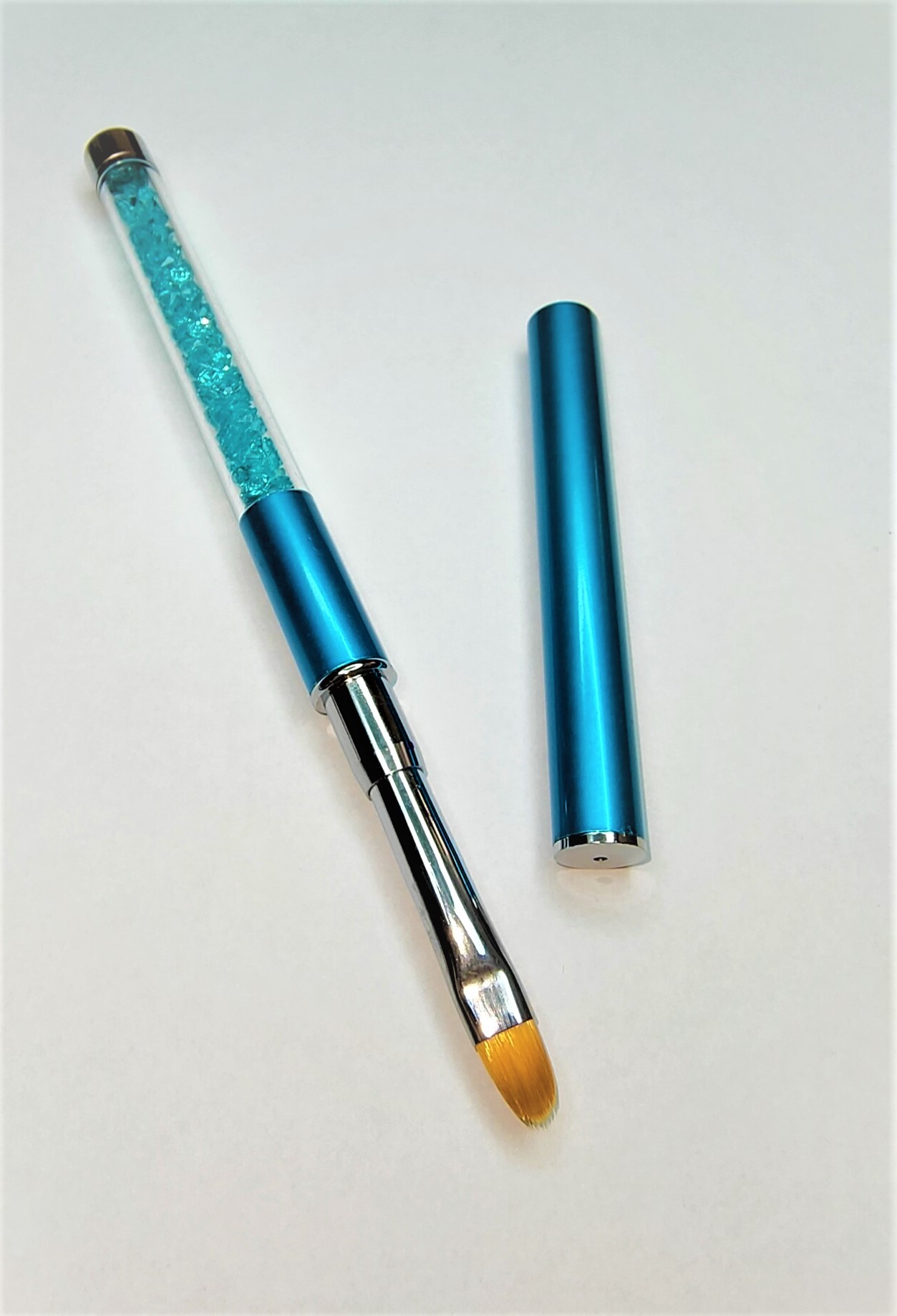 Pincel azul com cristais e tampa metálica separada