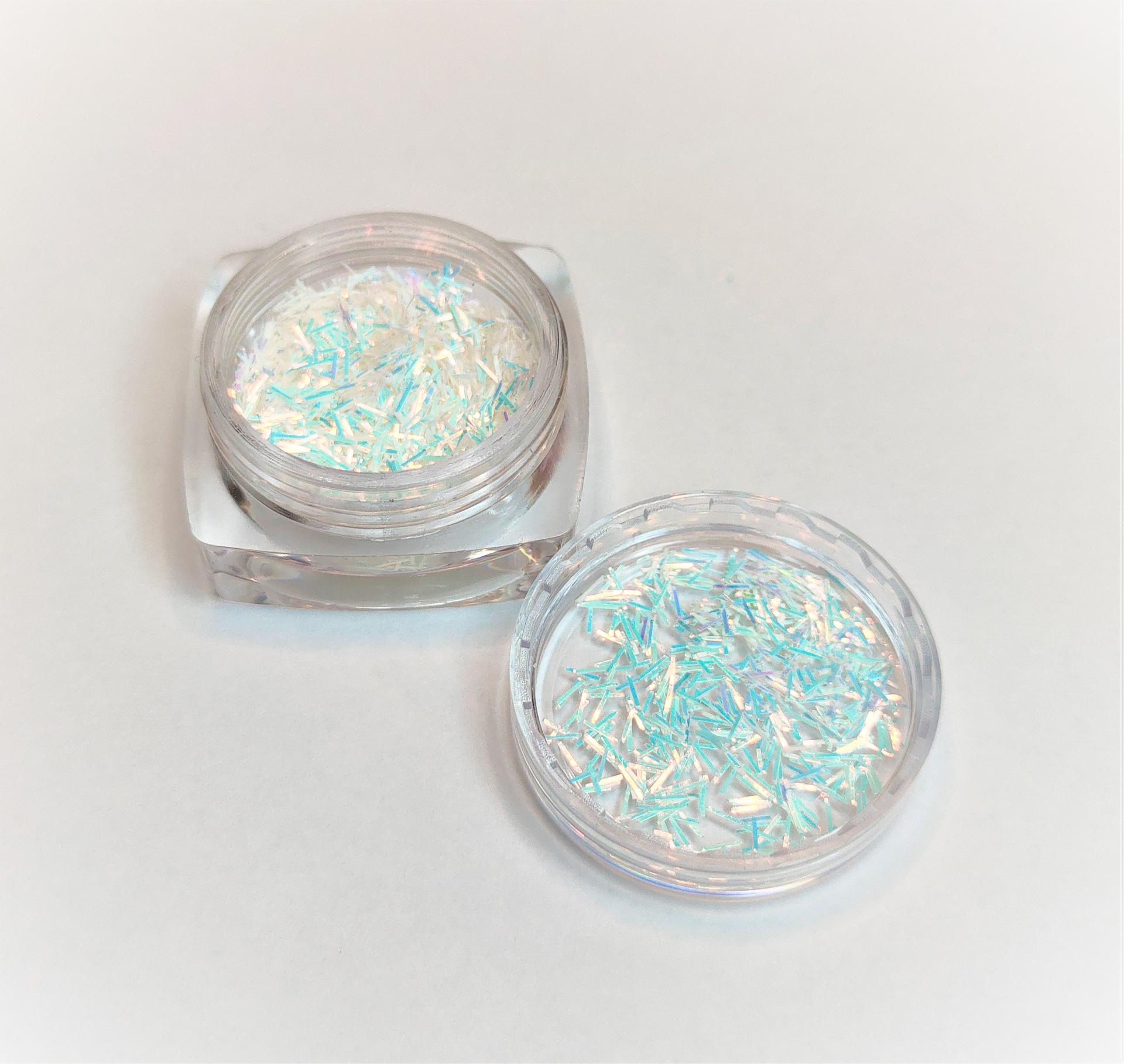 Frascos transparentes com pedaços brilhantes iridescentes