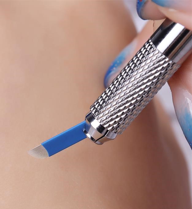 Ferramenta metálica com lâmina azul de cerdas finas segurada por mão com unhas decoradas