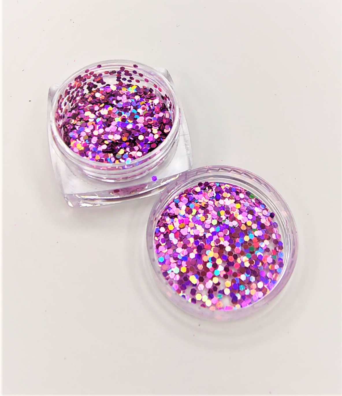 Duas caixas transparentes com glitter colorido rosa e roxo