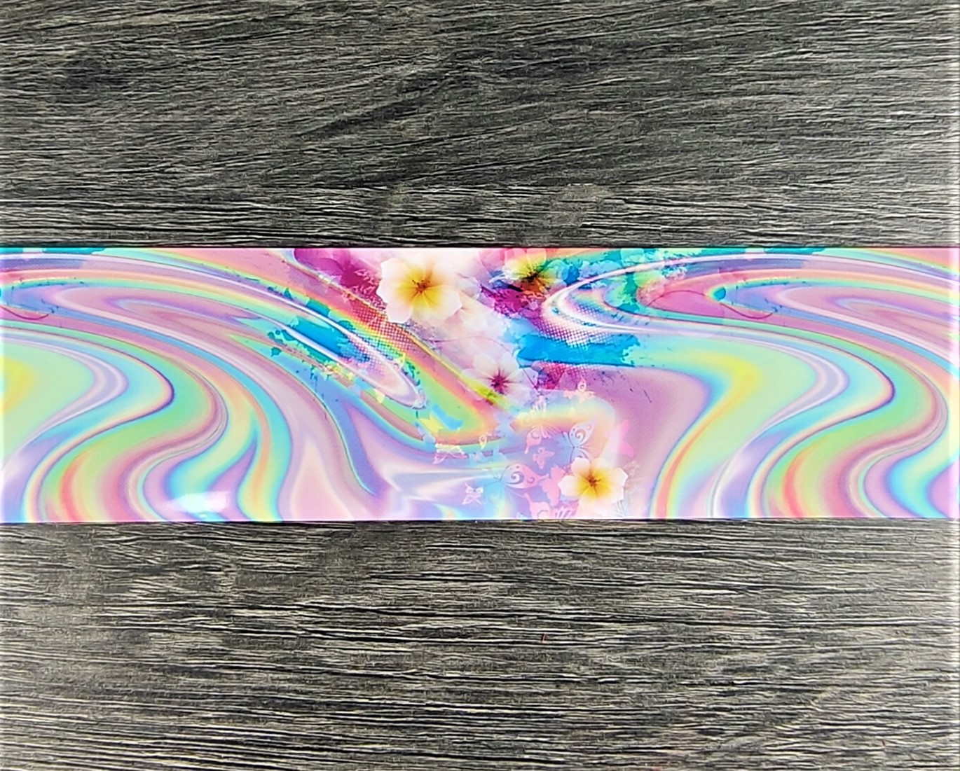 Tapete retangular colorido com padrão abstrato e flores sobre chão de madeira cinzenta