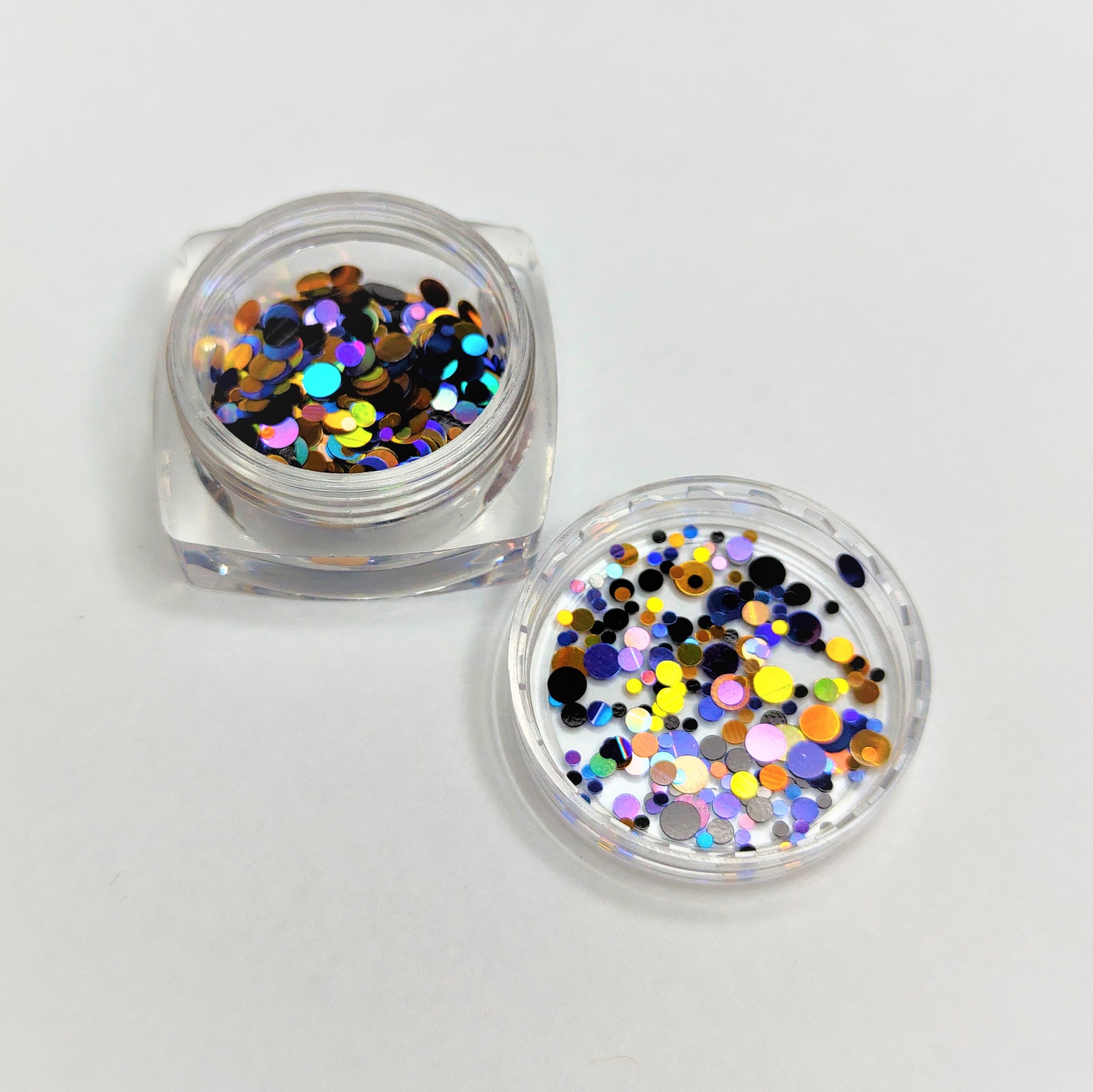 Dois frascos de purpurinas coloridas circulares em plástico transparente