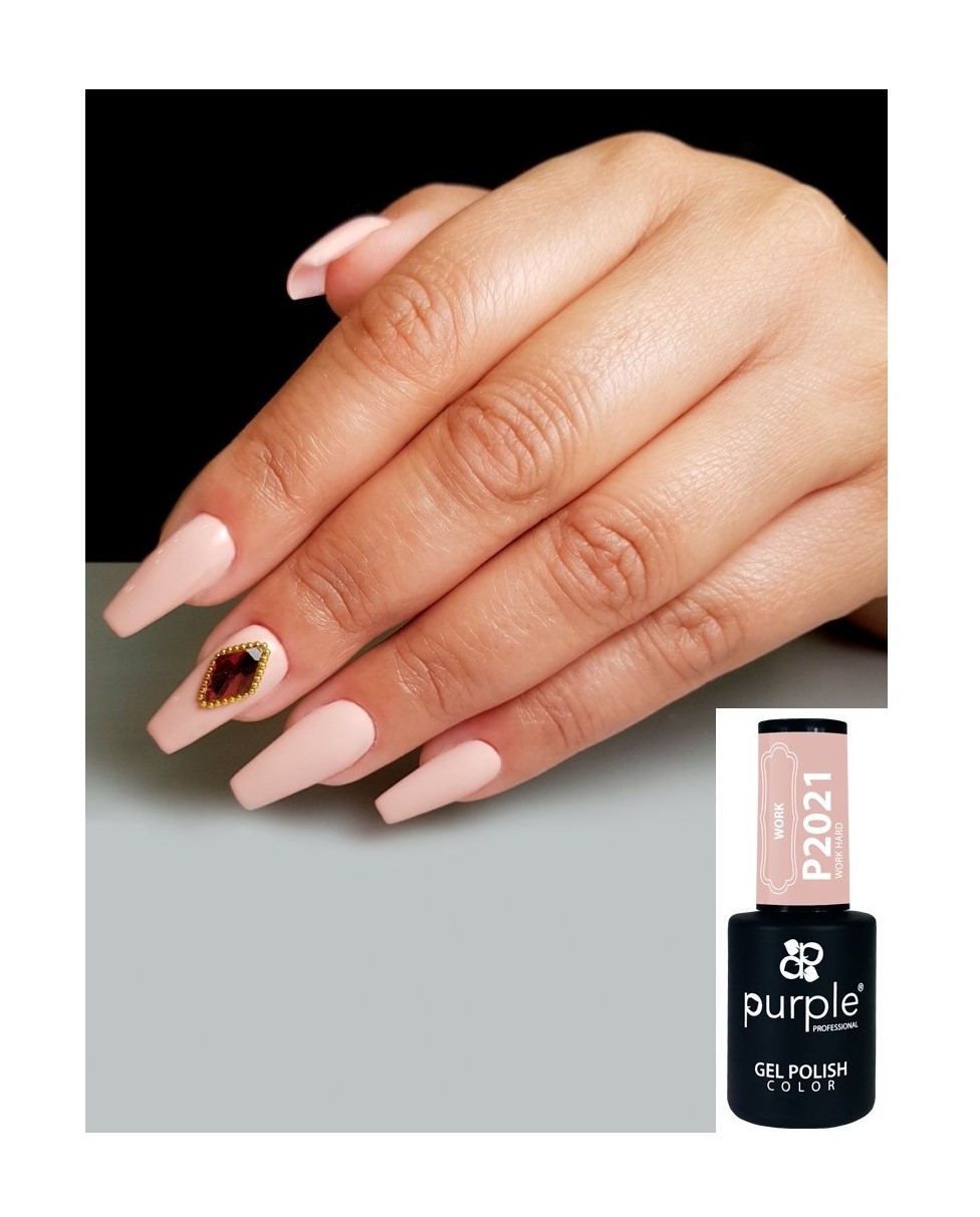 Mãos femininas com unhas longas nude claro e uma decorada com coração, próximo a um frasco de verniz purple P2021