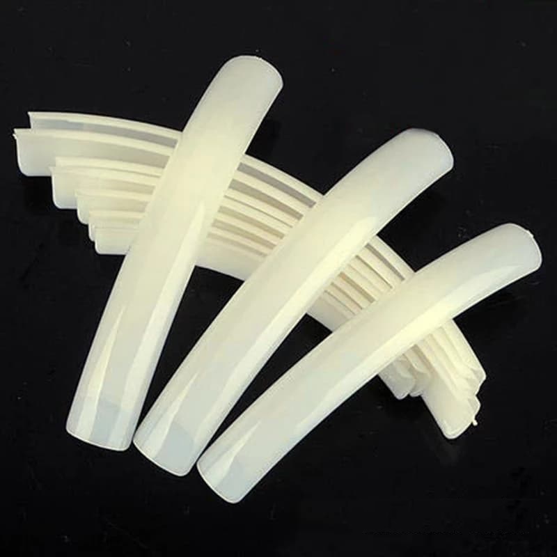 Peças de plástico branco curvilíneas com ranhuras em fundo preto