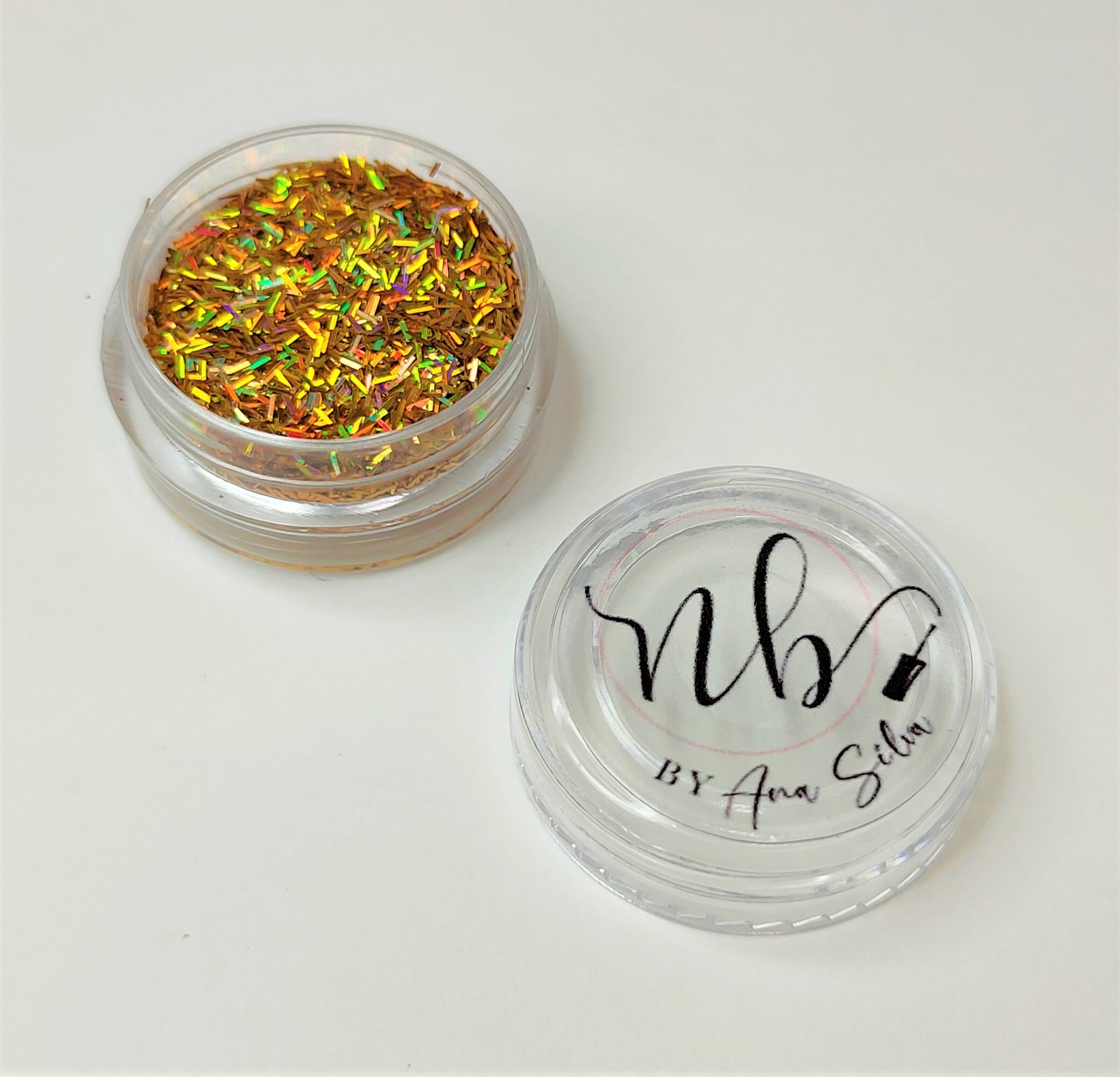 Embalagem redonda com glitter dourado colorido e tampa transparente com texto nb by Ana Silva