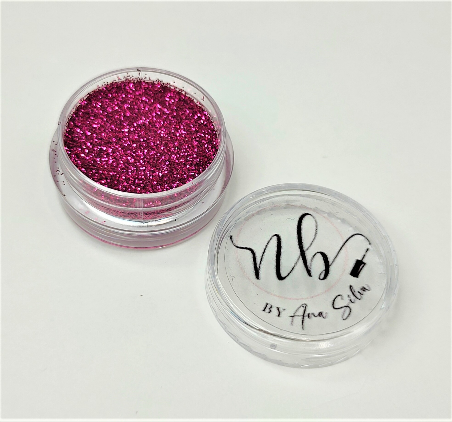 Recipiente plástico com pó brilhante rosa fúcsia e tampa com texto nb BY Ana Silva