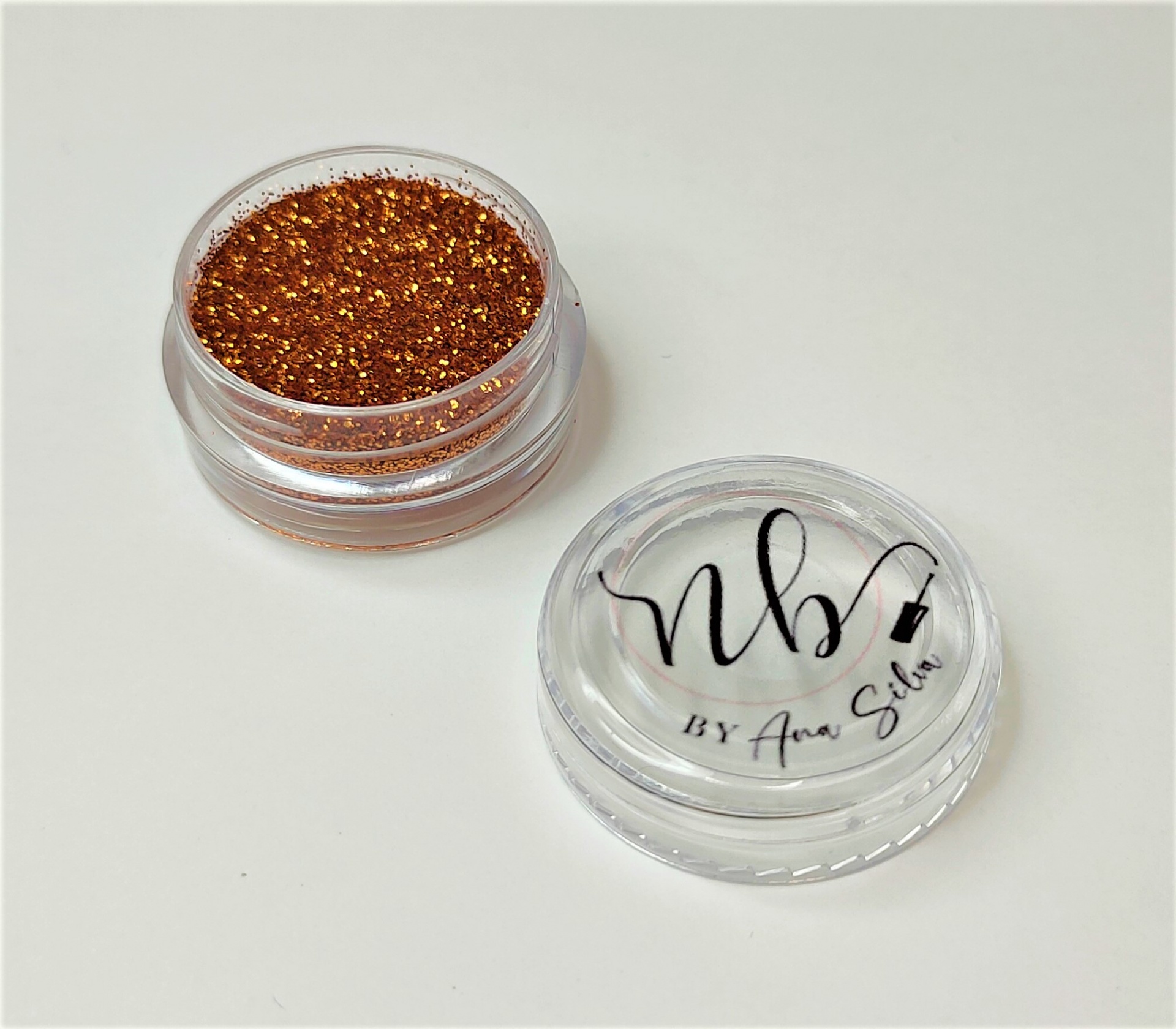 Frasco de glitter dourado com tampa transparente e texto NBV BY Ana Silva