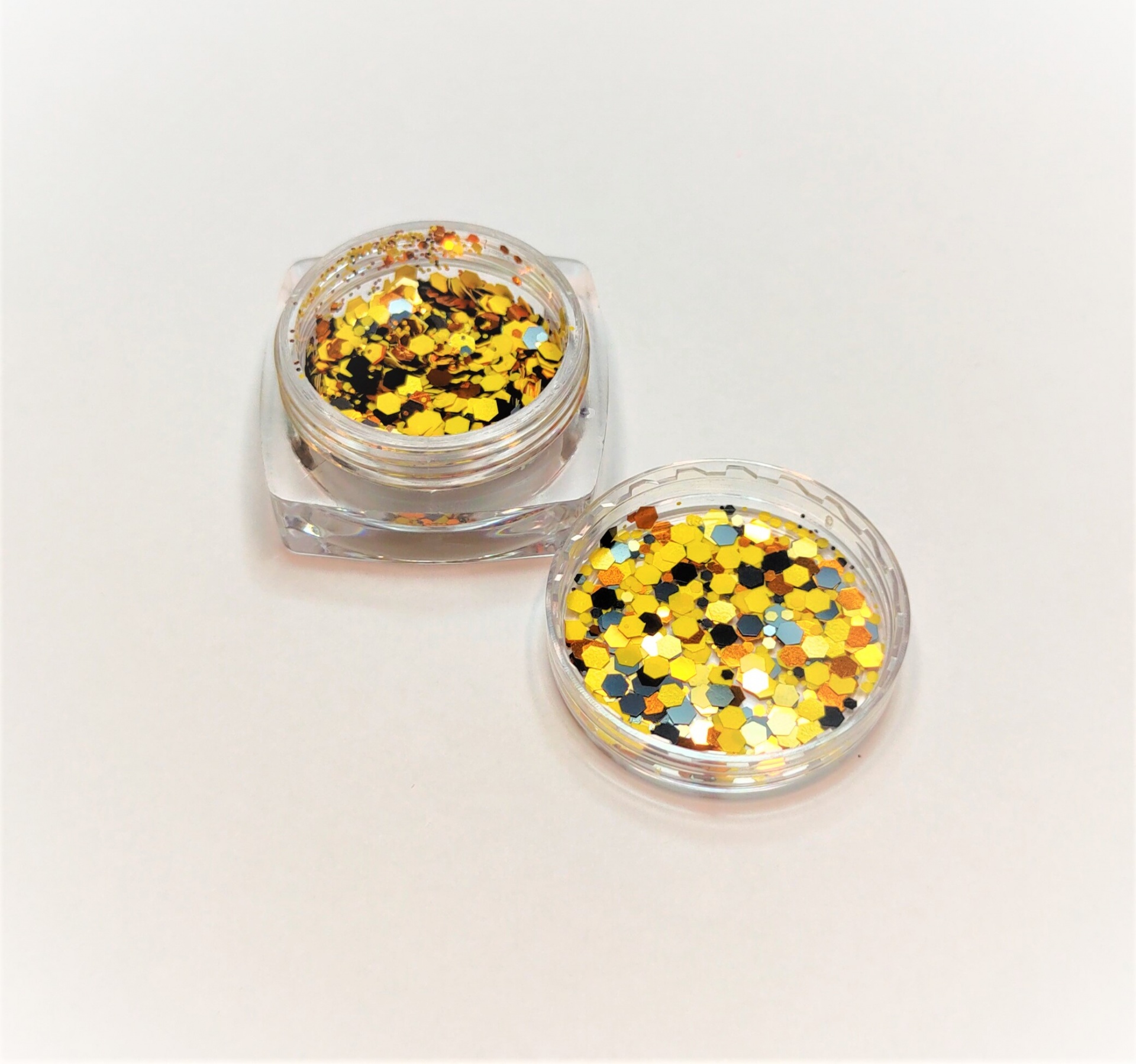 Pote transparente com purpurinas coloridas amarelas, douradas, brancas e pretas