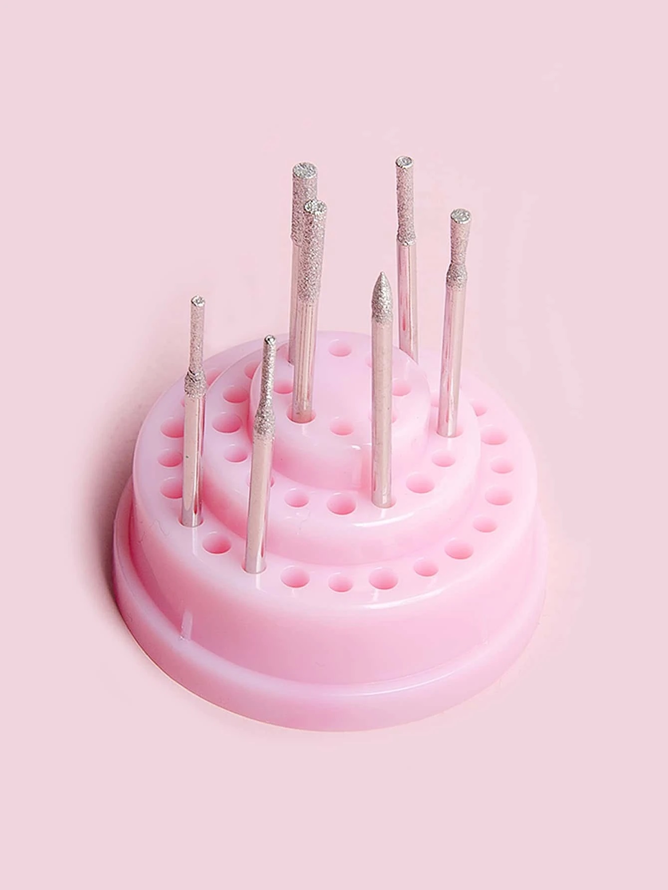 Ferramentas de unhas em base rosa em fundo rosa