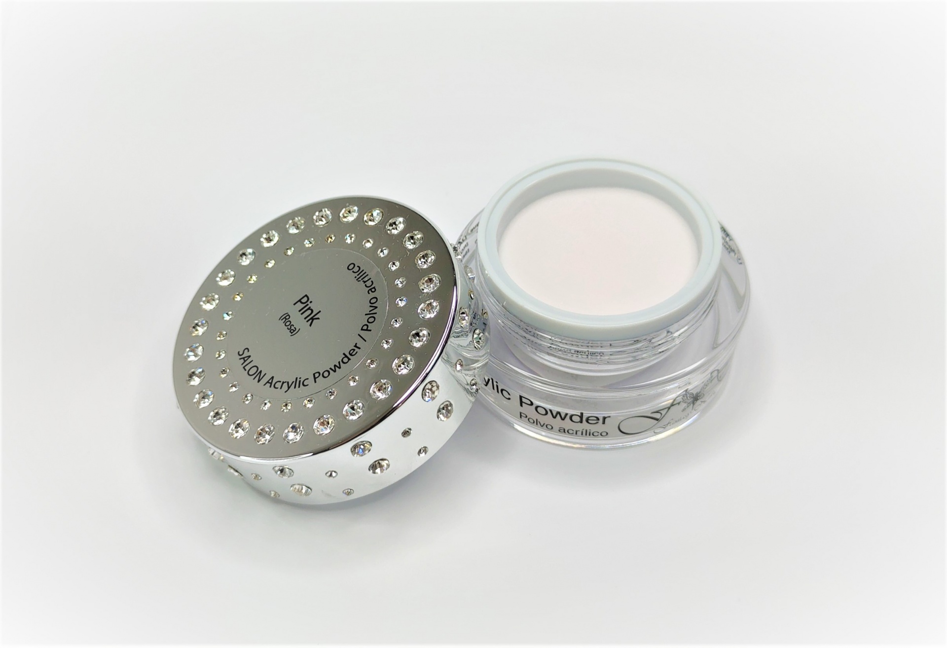 Pote transparente com pó em creme rosa claro e tampa prateada com pedras brilhantes