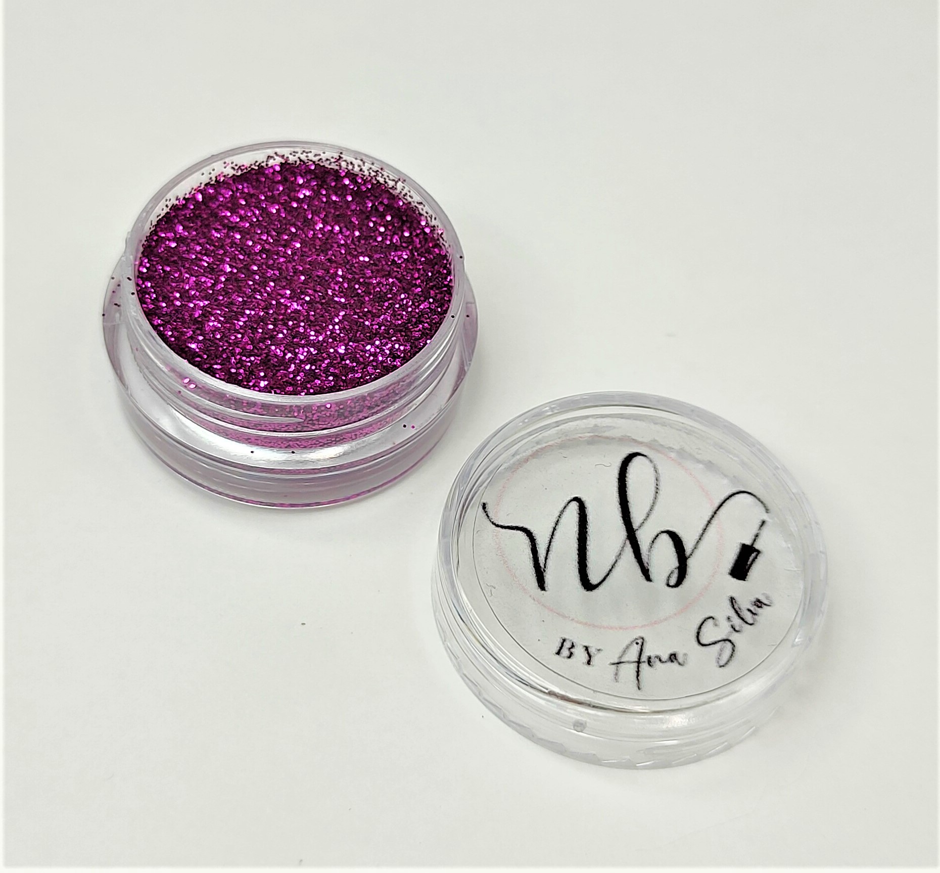 Pote transparente com glitter rosa metálico e tampa com logotipo e texto preto