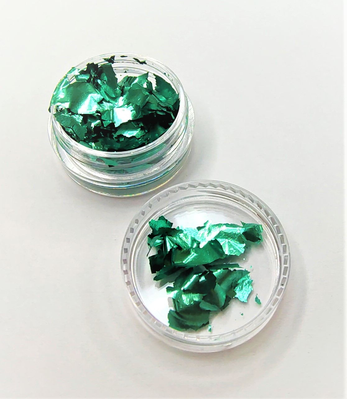 Pote transparente com pedaços de folha metálica verde brilhante