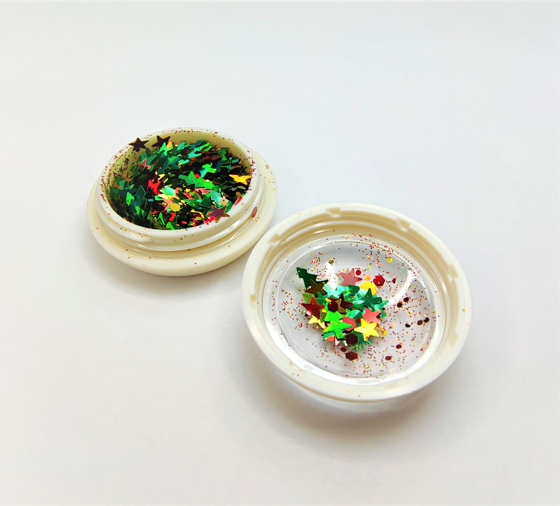 Frasco pequeno aberto com glitter em forma de estrelas coloridas