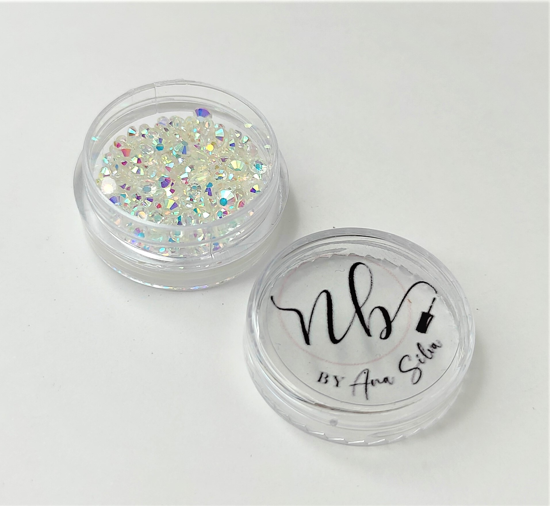 Recipiente transparente com glitter branco holográfico e tampa com texto 'Nbs BY Ana Silva'