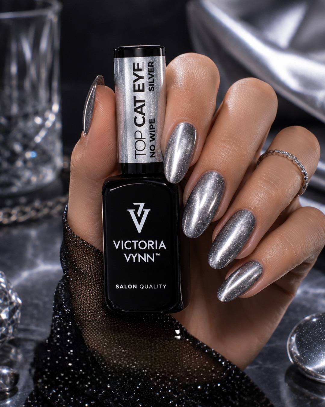 Frasco de verniz VICTORIA VYNN com unhas prateadas brilhantes e fundo prateado