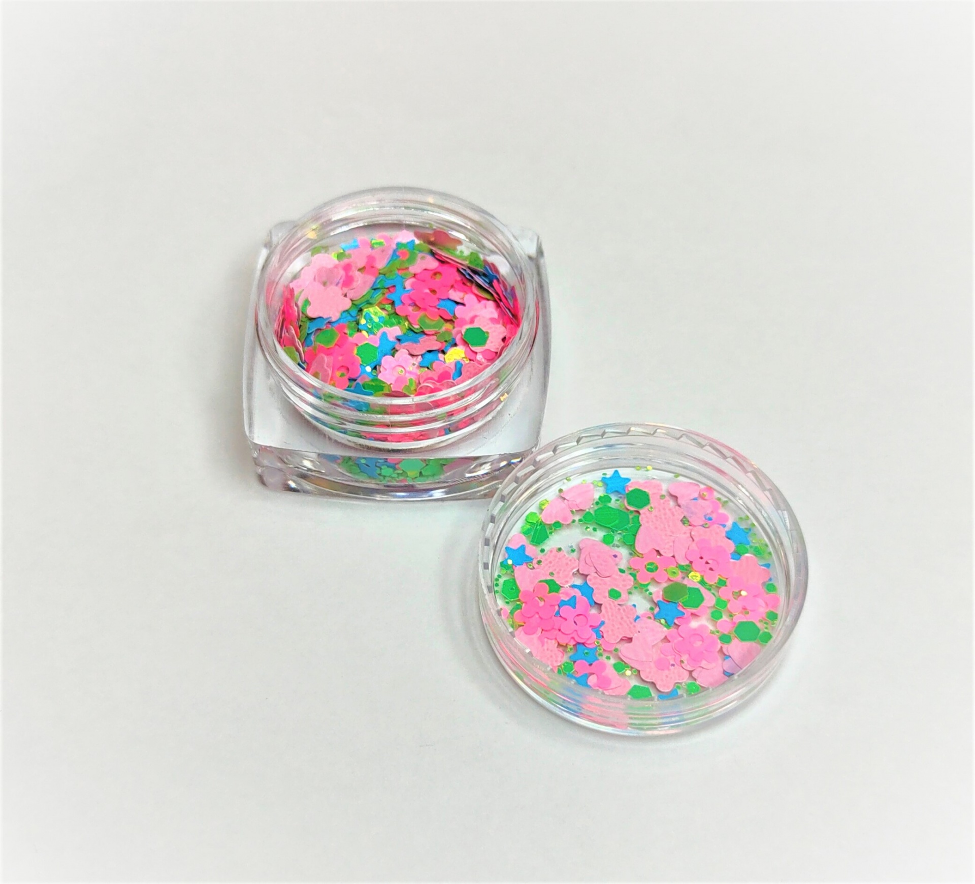 Caixas transparentes com confetes coloridos em formato de flores