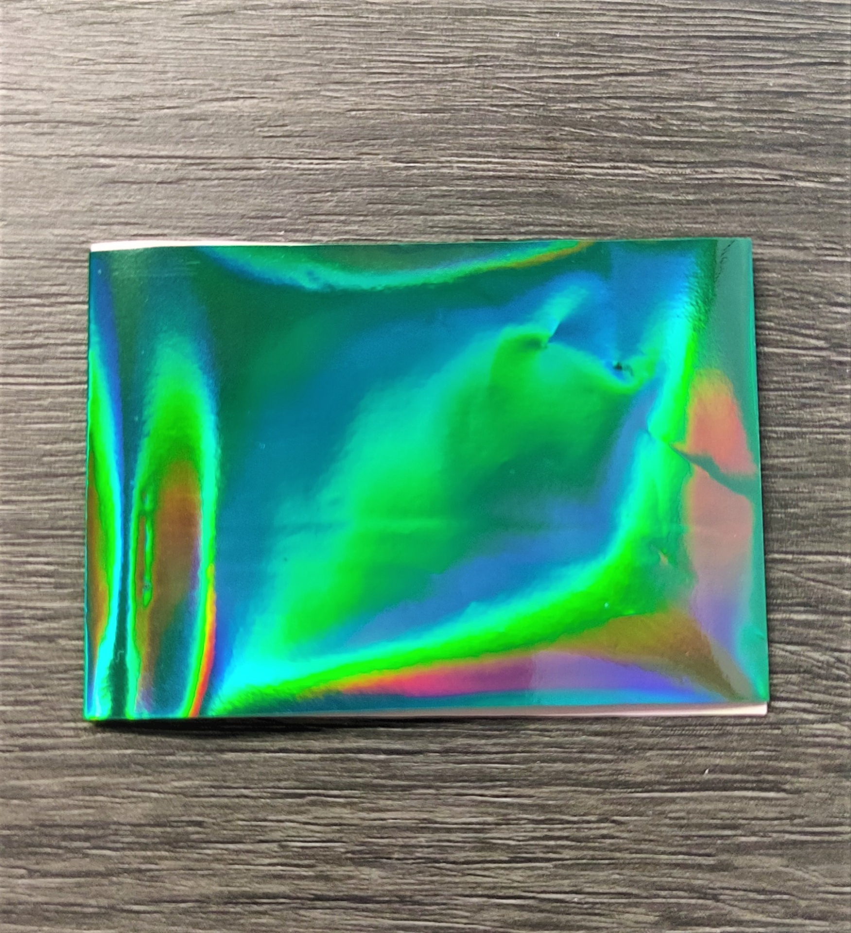 Saco metálico holográfico pequeno com fundo de madeira cinzenta