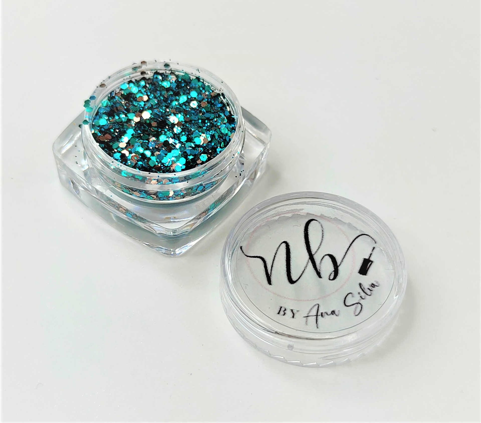 Pote pequeno com purpurina azul e prata e tampa com logótipo.