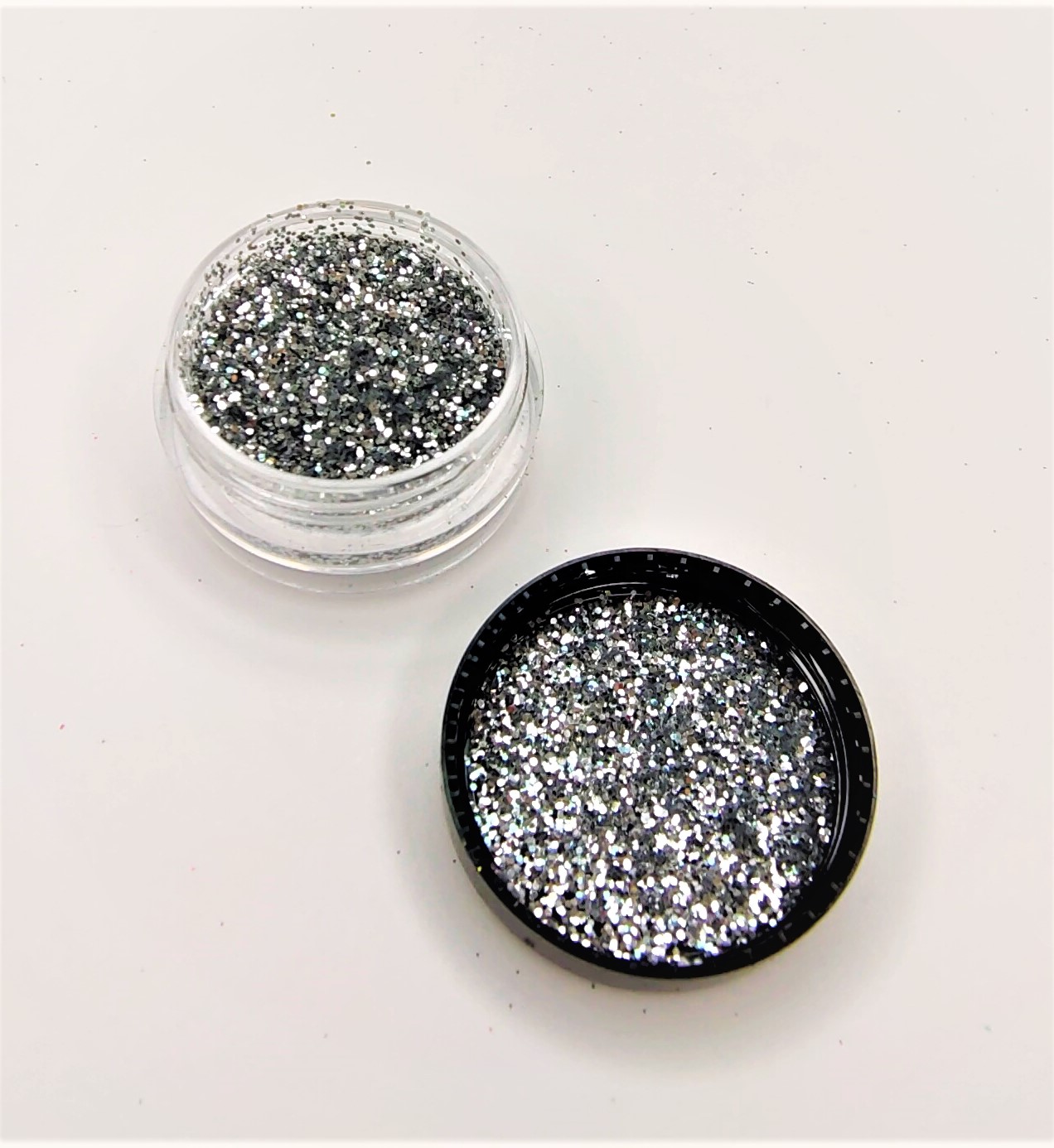 Frasco pequeno transparente com glitter prateado e tampa preta