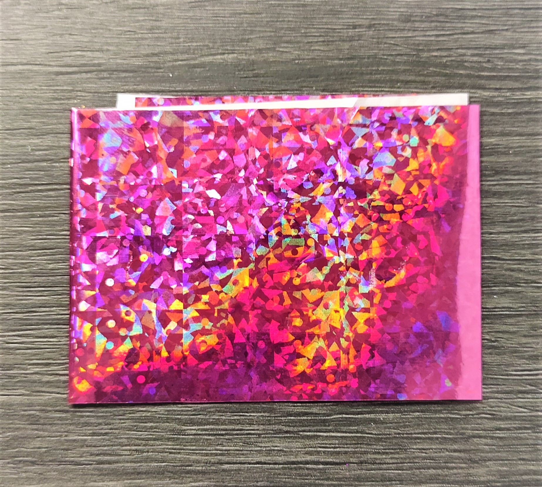 Pacote holográfico colorido sobre superfície de madeira cinzenta