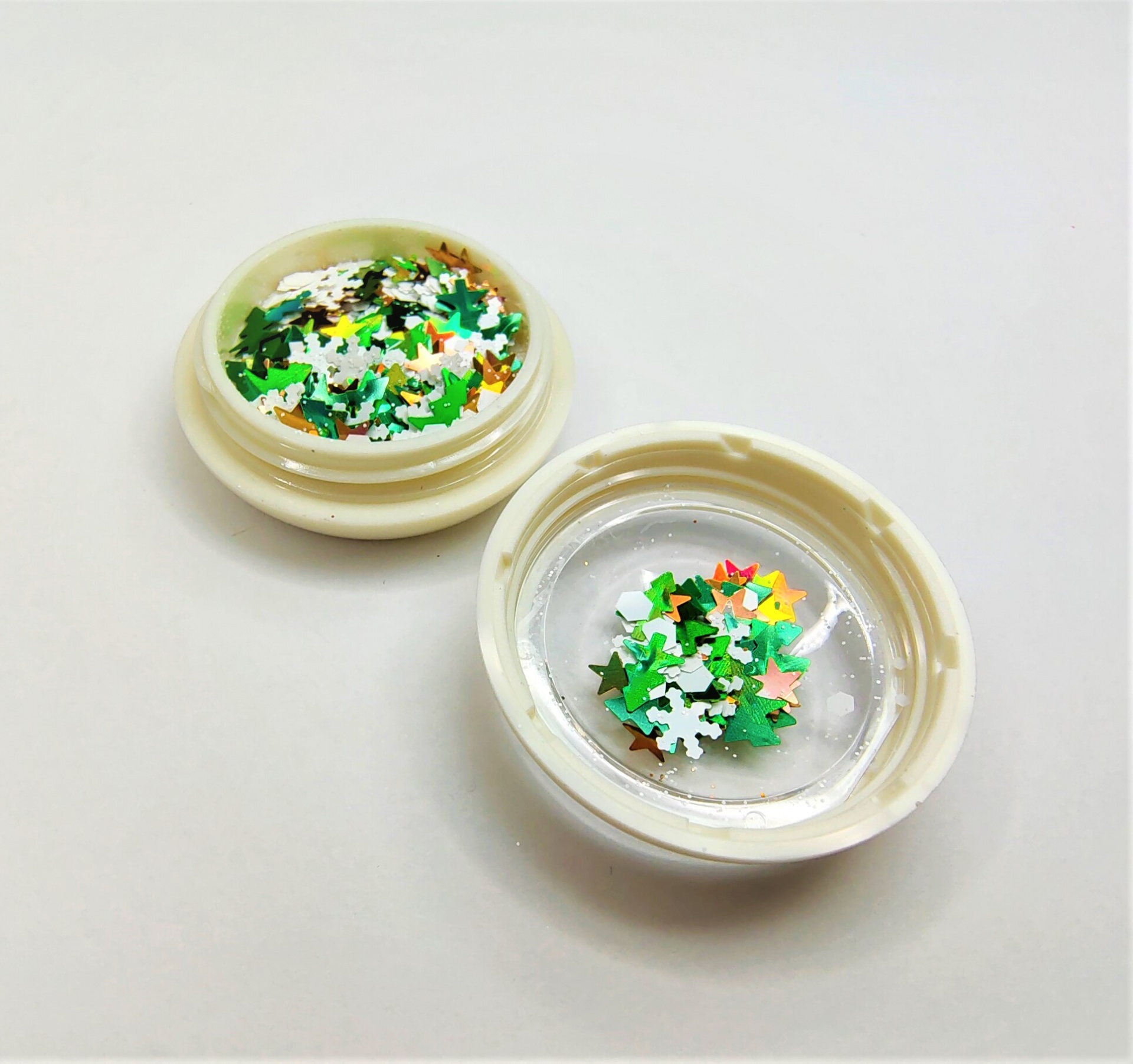 Frasco aberto com glitter de estrelas coloridas em verde, branco e dourado