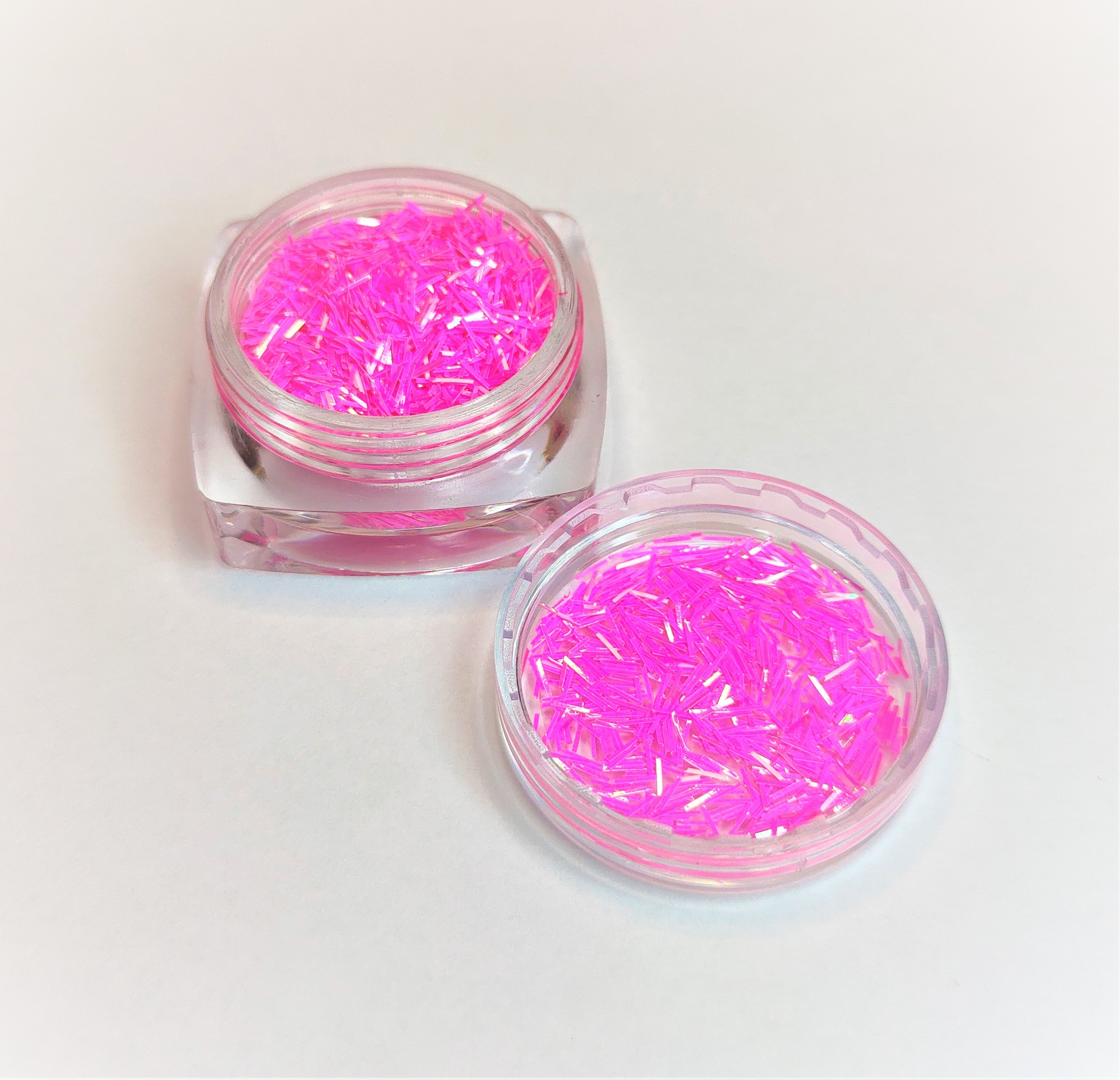 Dois recipientes com glitter rosa em tiras finas