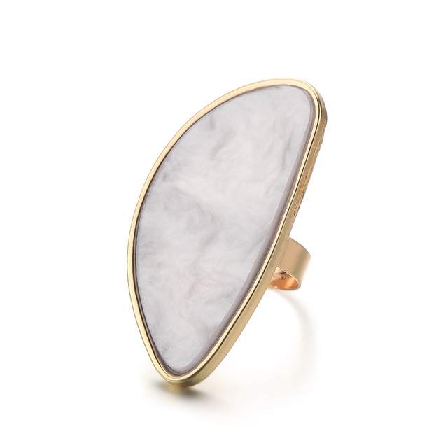 Anel dourado com pedra branca oval e textura marmoreada