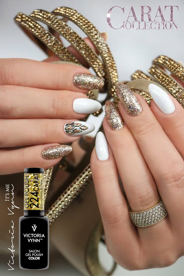 Unhas com verniz gel branco e dourado brilhante com anel de pedras e decoração dourada ao fundo