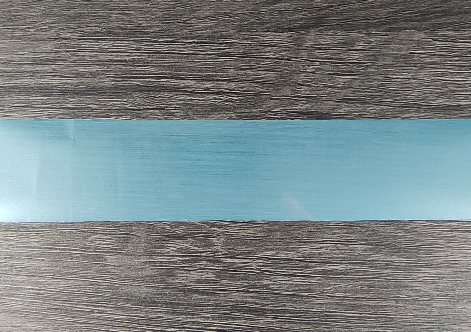 Fita azul clara sobre superfície de madeira cinzenta