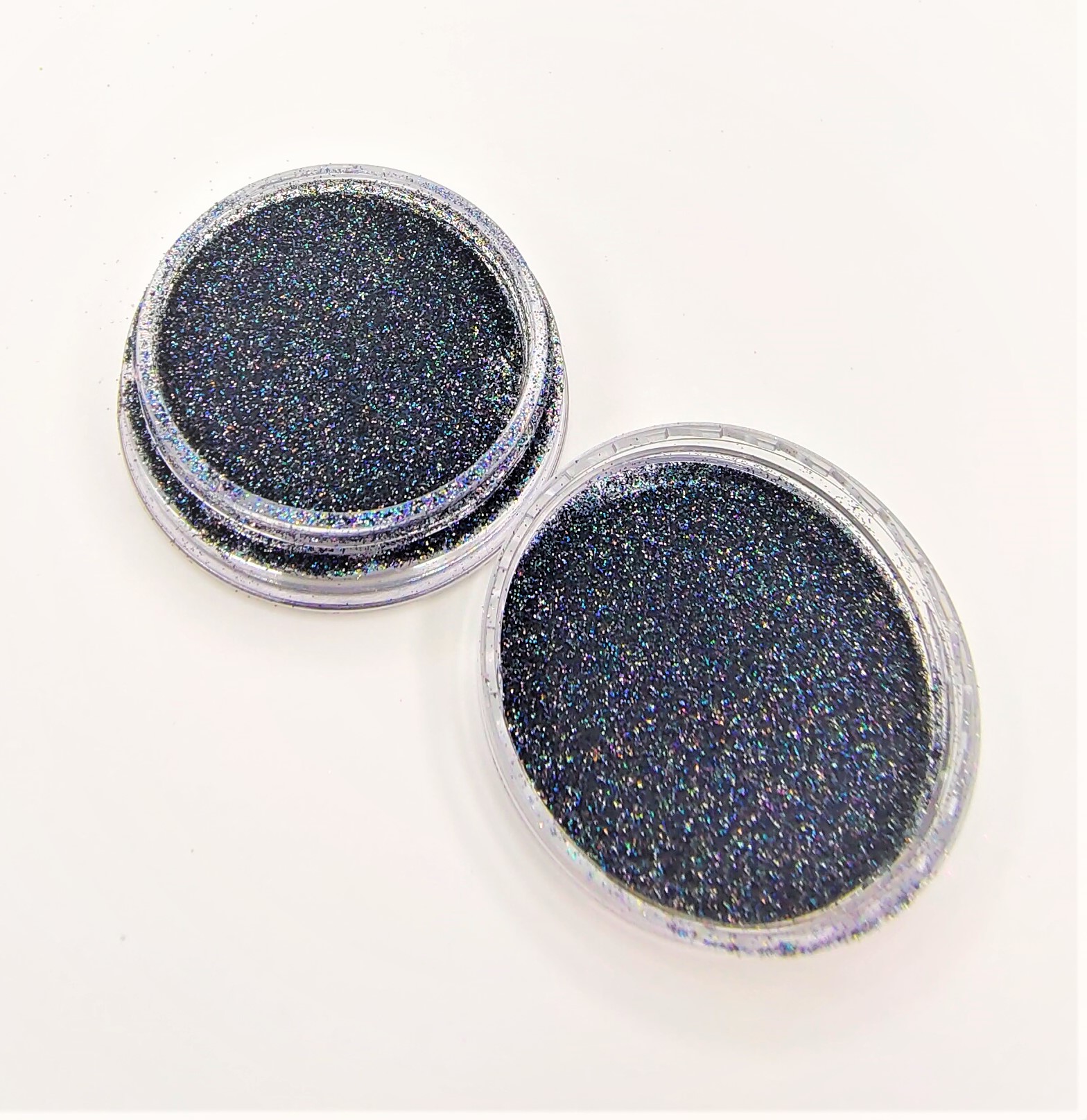 Recipientes transparentes com glitter preto holográfico brilhante.