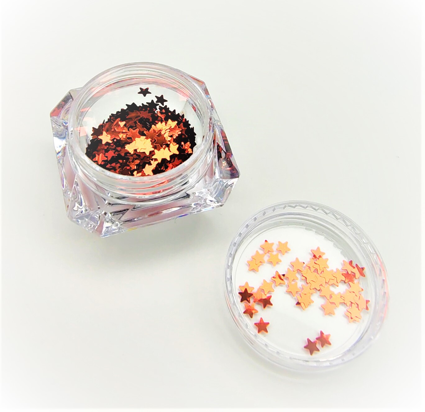 frasco acrílico transparente com lantejoulas em forma de estrelas douradas e cobre